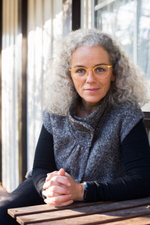 Diana Schaper, Portrait einer Frau mit grauer Weste und langen grauen Locken