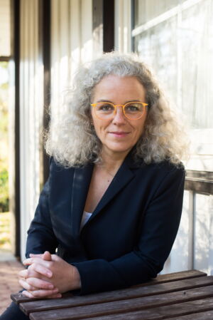 Diana Schaper, Portrait mit dunklem Blazer und langen grauen Locken